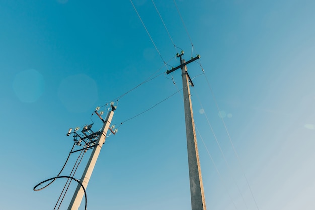 Линии электропередач на фоне голубого неба крупным планом
