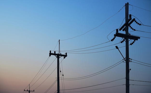 Power lines in the evening with a pink and blue sky in the background.