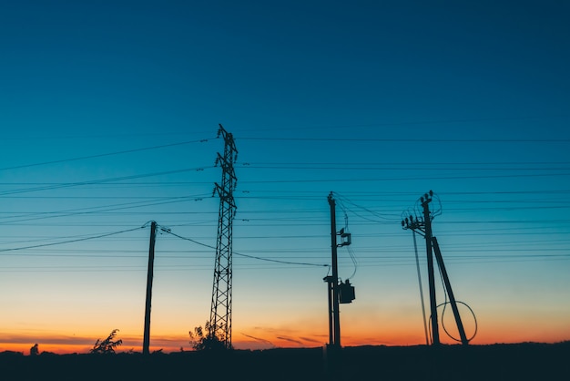 Power lines in field in sunrise