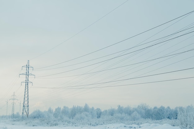 雪の降る冬の風景の中の送電線