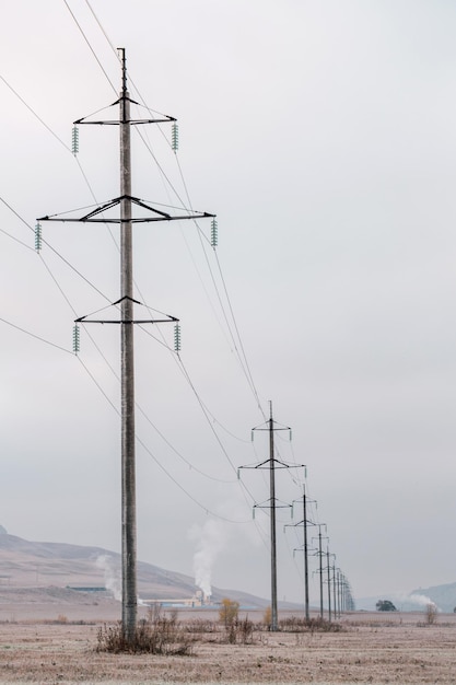 写真 遠くまで伸びる送電線。日の出の柱の展望。フィールドの孤独な風景。空のフィールドの電力線。