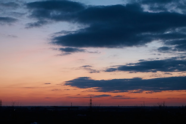 Power lines, wires, poles and industrial zone at sunset