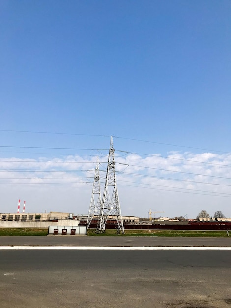 Power plant with high metal highvoltage towers and wires pillars against the background
