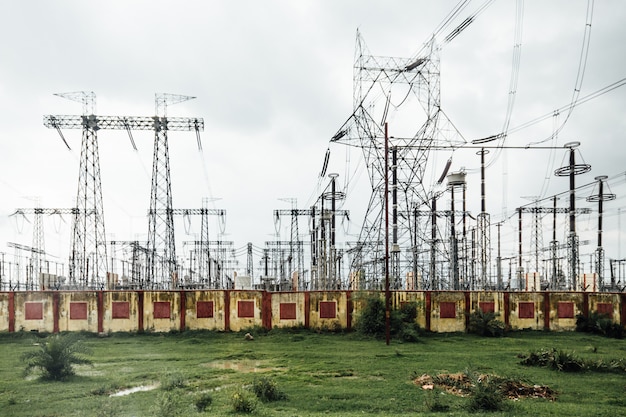 Электростанция с высоковольтными электрическими столбами на обочине дороги в Варанаси, Индия.