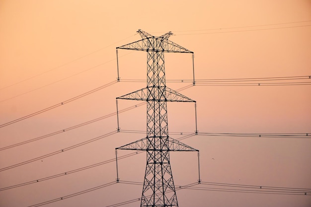 A power pole with the sun setting behind it