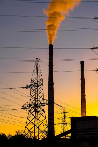 Foto piloni di potenza sullo sfondo dell'ora del tramonto. torre elettrica ad alta tensione. messa a fuoco selettiva