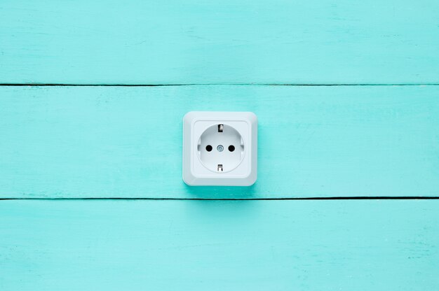 Power socket on blue wooden wall, 