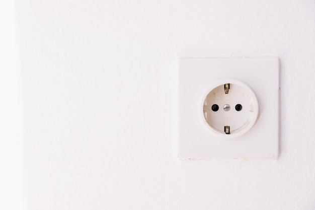 Power socket on the empty white wall