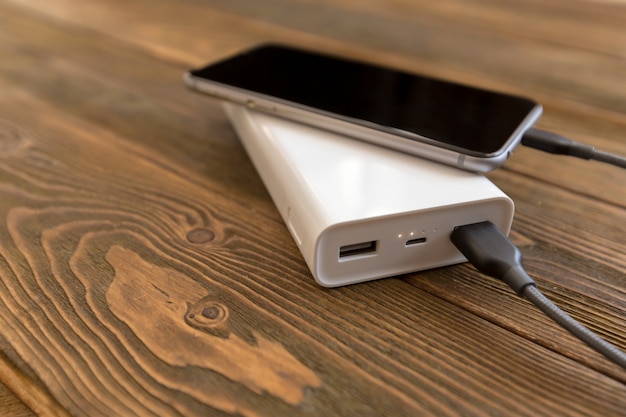 Powerbank e cellulare sulla tavola di legno