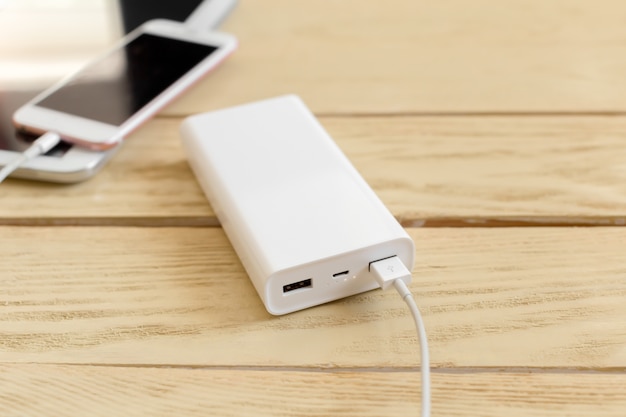 Powerbank en mobiele telefoon op houten tafel