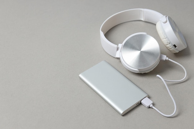 Powerbank and headphone hand on gray background space for text