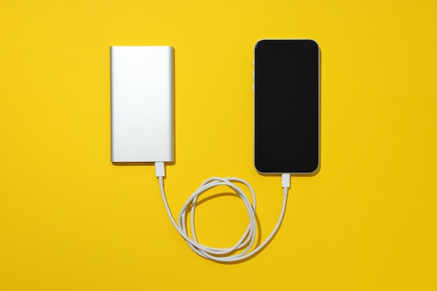 Powerbank met een smartphone op een gele achtergrond