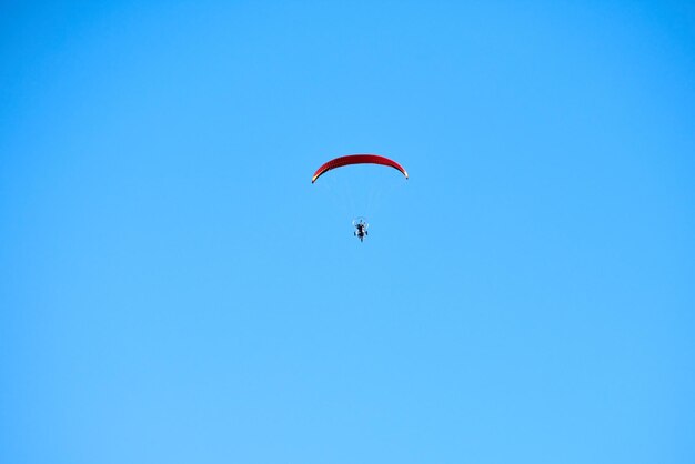 Paracadute motorizzato nel cielo azzurro, vista dall'alto del paracadute motorizzato, spazio per le copie. turista con volo pilota in paraplano. turismo estremo, concetto di sport estremo