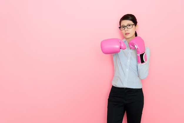 powerful businesswomen wearing the boxing gloves showing punch