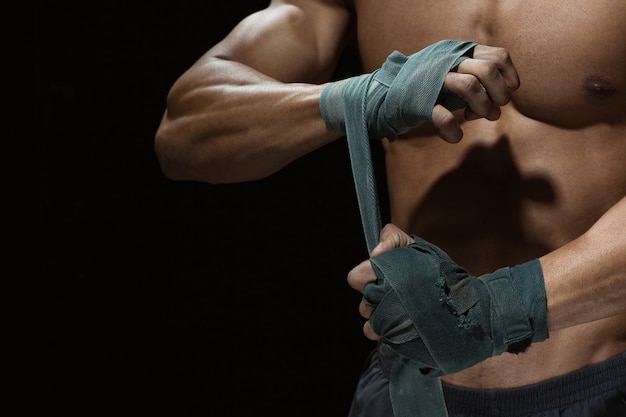 Powerful fighter. Cropped shot of a well built fighter doing bandages