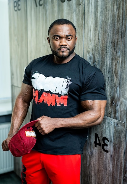 Powerful fitness man posing in gym stylish strong man posing
with cap