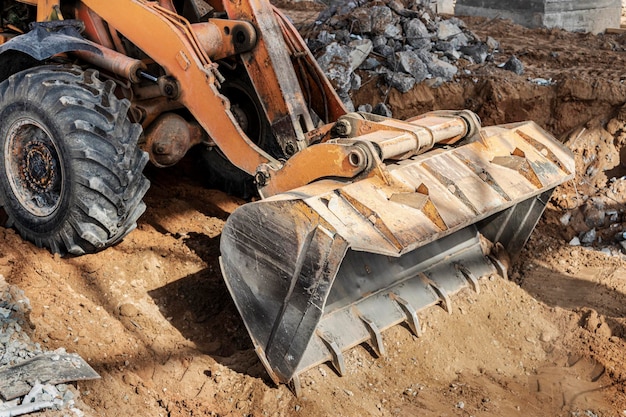 建設現場の強力なフロントローダーは、鉄筋コンクリート構造物を解体した後、戦いをクリアします。建設機械で土を動かす。発掘調査。