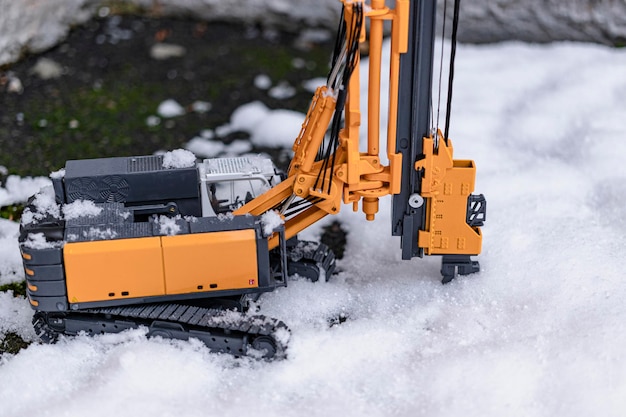 Powerful hydraulic drilling rig for the installation of bored piles in the winter in the snow at the construction site. Drilling rig in northern conditions. Bored piles. Close-up. Selective focus.