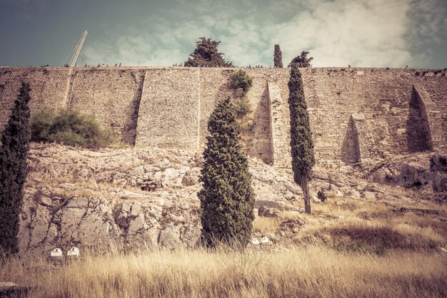 Powerful wall of the Acropolis hill in Athens Greece