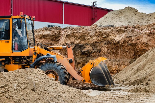 Foto potente pala gommata o bulldozer che lavora in una cava o in un cantiere primo piano di lavori di sterro potenti attrezzature moderne per lavori di sterro