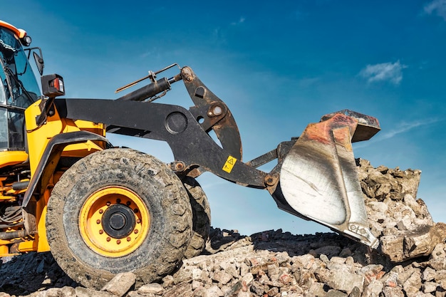 Foto potente pala gommata o bulldozer che lavora in una cava o in un cantiere lavori di sterro in costruzione potenti attrezzature moderne per lavori di sterro