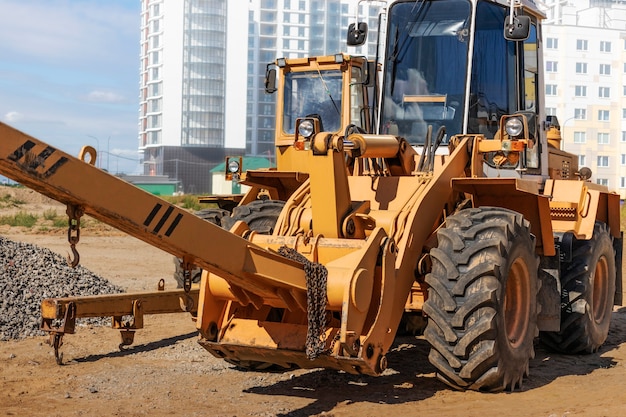 Photo powerful wheel loader for transporting bulky goods at the construction site of a modern residential area. construction equipment for lifting and moving loads.