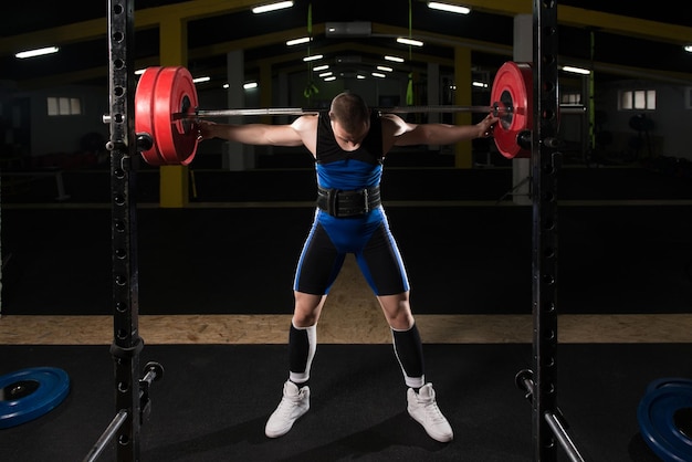 Photo powerlifter doing exercise for legs with barbell