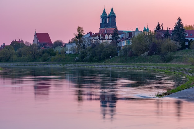 Cattedrale di poznan sull'isola di ostrow tumski e fiume warta all'alba rosa, poznan, polonia.