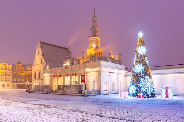 雪に覆われたクリスマスの夜のポズナンポーランドの旧市街の旧市場広場にあるポズナン市庁舎