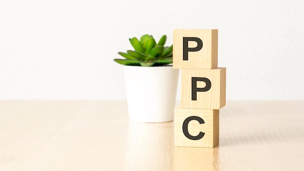 PPC は、木製の backround ビジネス コンセプトの木製キューブの頭字語をクリックごとに支払う