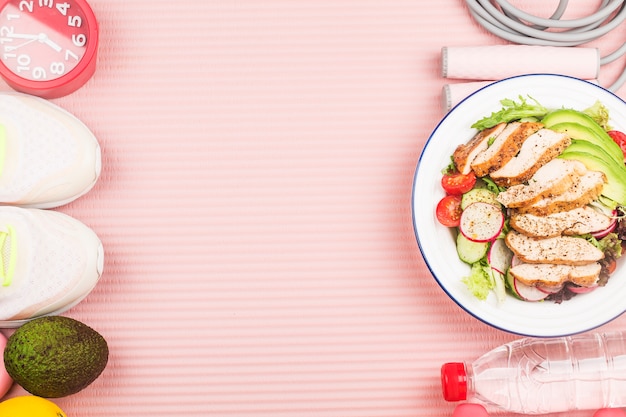 Pplate of chicken breast salad with ingredients and skipping rope