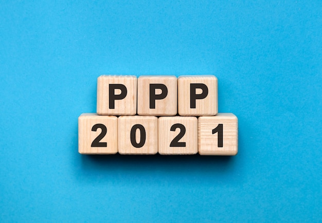 PPP - tekstconcept op houten kubussen met blauwe achtergrond met kleurovergang.