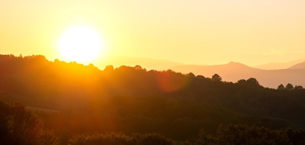 Prachtig berglandschap met wazige toppen en mistige vallei bij zonsondergang.