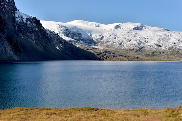 Prachtig blauw meer in de besneeuwde Noorse bergen onder de blauwe lucht