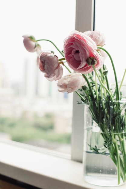 Prachtig boeket met roze pioenrozen bloemen voor het raam