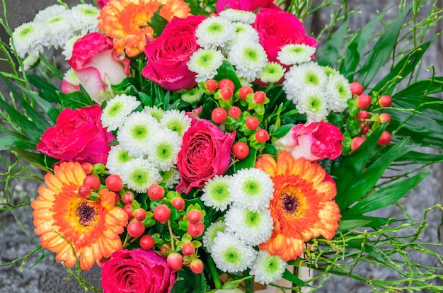 Foto prachtig boeket met verse roze rozen, gerbera's, madeliefjes, hypericum met dauwdruppels