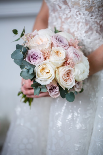 Prachtig bruidsboeket bloemen in de handen van de pasgetrouwden