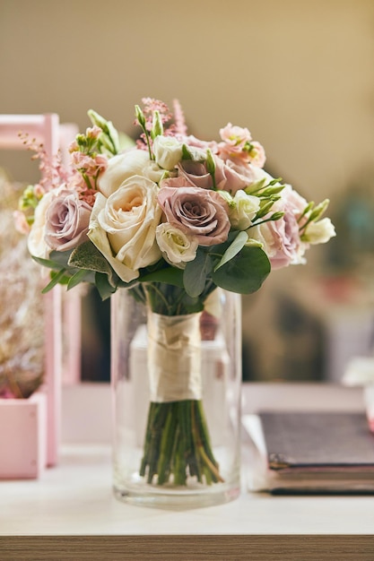 Prachtig bruidsboeket met rozen die op tafel staan