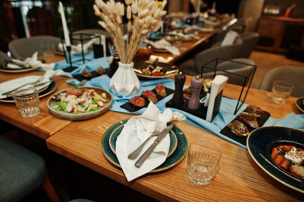 Prachtig gedekte tafels met eten, glazen en apparaten in restaurant.