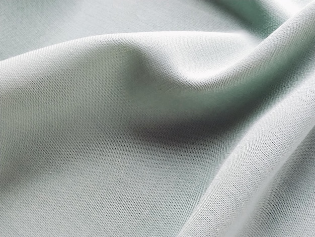 Prachtig gevouwen lichtgroene stof Zachte aangename golven en volants op textiel Close-up draperie voor gordijnen stof voor kleermakerij of stoffering