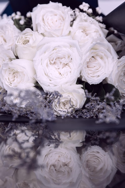 Prachtig groot en een luxe boeket witte rozen gerangschikt in een bos met reflectie op de vloer