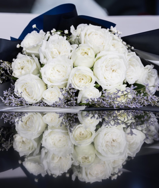 Foto prachtig groot en een luxe boeket witte rozen gerangschikt in een bos met reflectie op de vloer