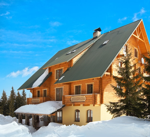 Prachtig houten huis op een pittoresk winterresort op een blauwe hemelachtergrond