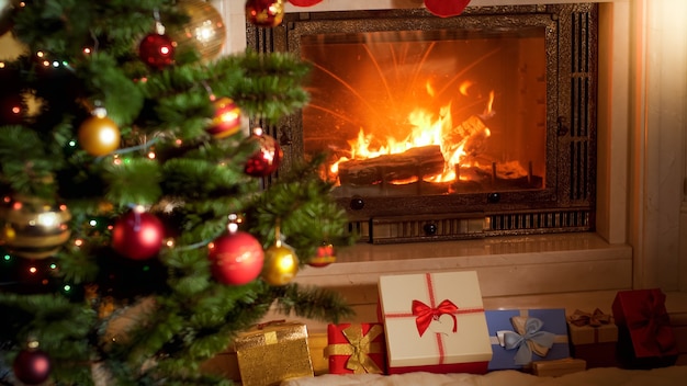 Prachtig interieur met brandend haardvuur, kerstboom en grote stapel kerstcadeaus