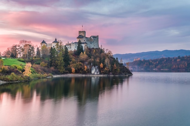 Prachtig kasteel aan het meer in de schemering in de herfst