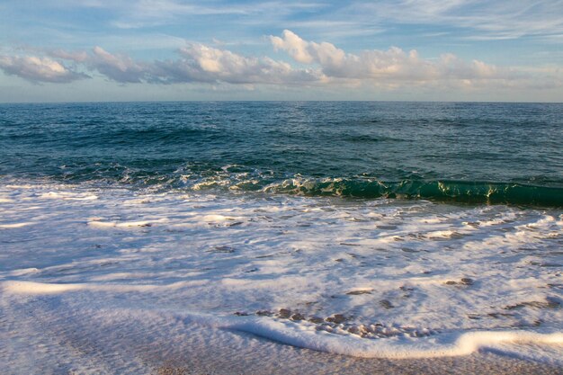 Prachtig landschap aan de kust van het strand en de golven van de zee tegen de achtergrond van de blauwe lucht