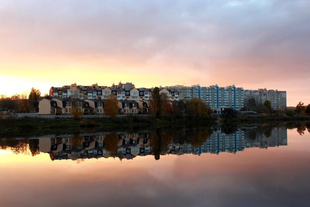 Prachtig landschap met zonsondergang rivier en modern huis weerspiegelt erin