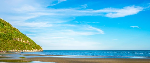 Prachtig landschap van de zee met bergen en een prachtig zandstrand met blauwe lucht in de ochtend