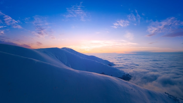 Prachtig landschap, zee van mist, besneeuwde bergtoppen en wolkenluchten en uitzicht op de bergen.