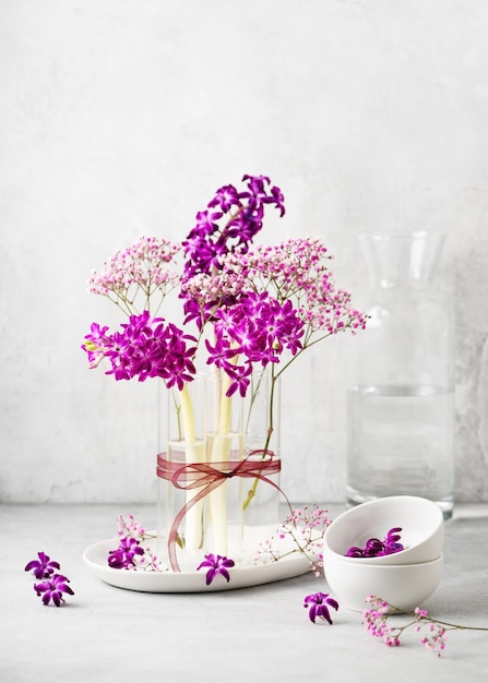 Prachtig lente floristisch arrangement met paarse hyacint en roze gypsophila bloemen in een glas